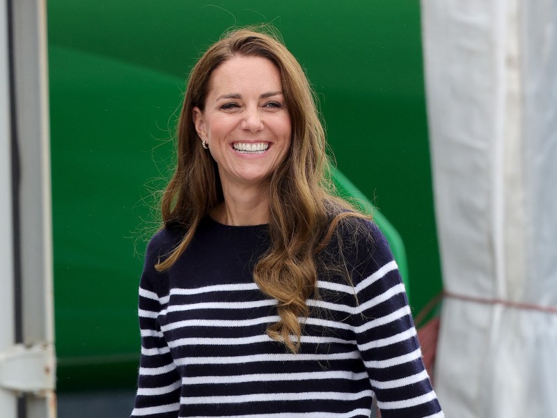 Kate Middleton smiling in a blue and white striped sweater