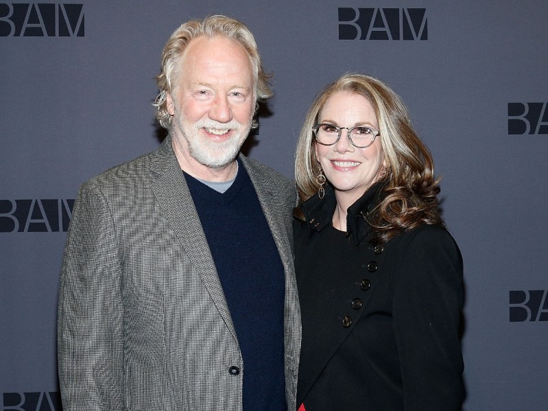 Melissa Gilbert (R) in black suit standing next to Timothy Busfield, who is wearing a gray suit jacket over a black shirt