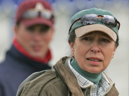 Princess Anne wears a hat, sunglasses, and a heavy coat outdoors
