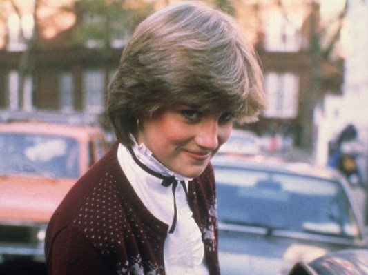 Princess Diana smiling in red cardigan