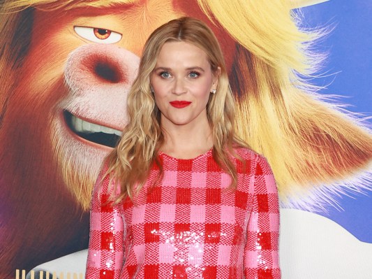 Reese Witherspoon smiling in a red dress at the Sing premiere