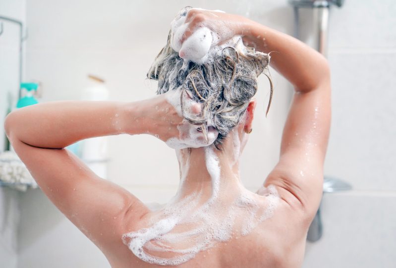 A woman in the shower washing her hair