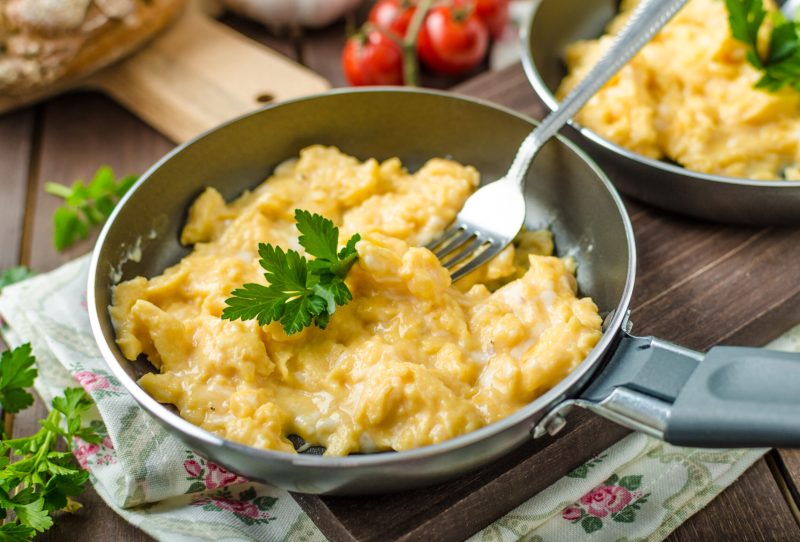 A pan filled with moist and fluffy scrambled eggs