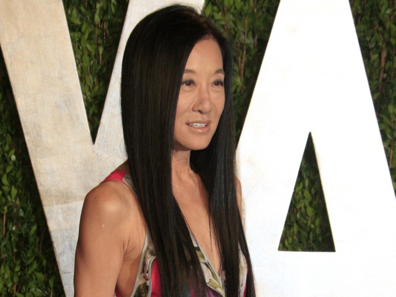 Vera Wang smiling in patterned dress against green backdrop with white lettering