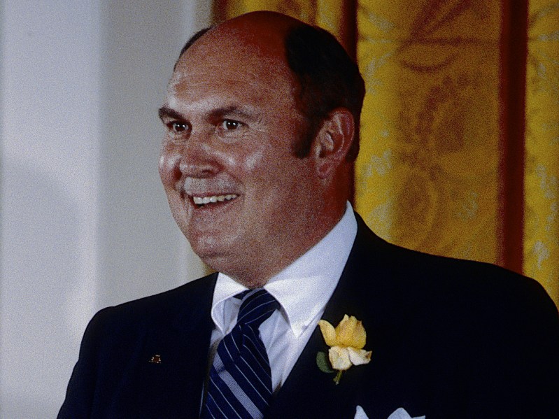 1986 photo of Willard Scott smiling in a navy suit at the White House