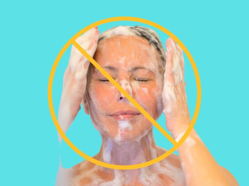 woman showering with suds on her face and hands