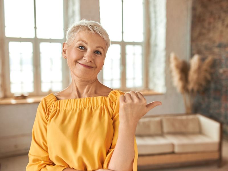 middle aged woman with gray pixie haircut giving thumbs up