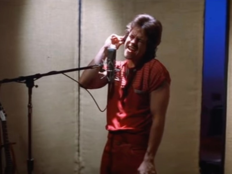 screenshot of Mark Wahlberg singing into a microphone from Boogie Nights