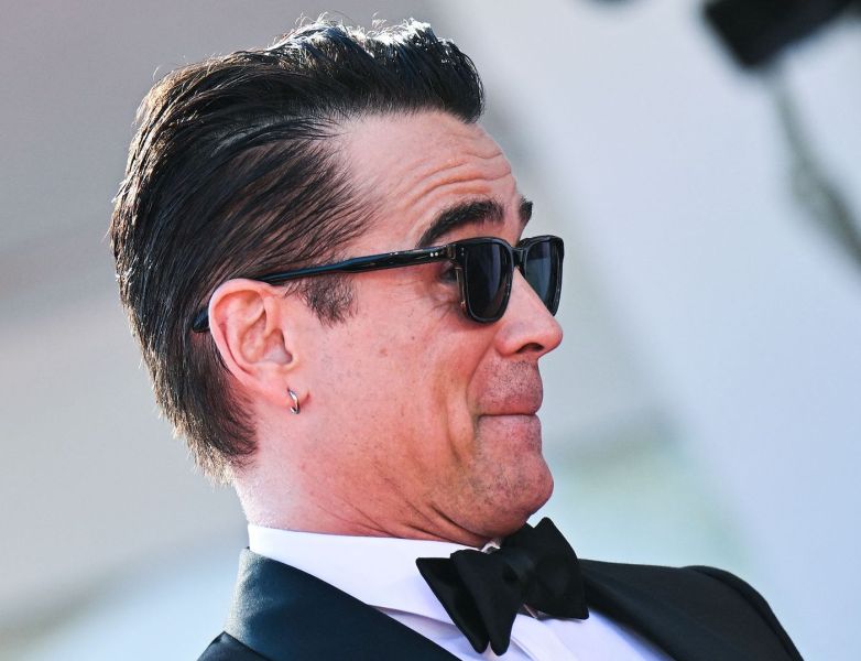close up of Colin Farrell in a tuxedo and sunglasses smiling