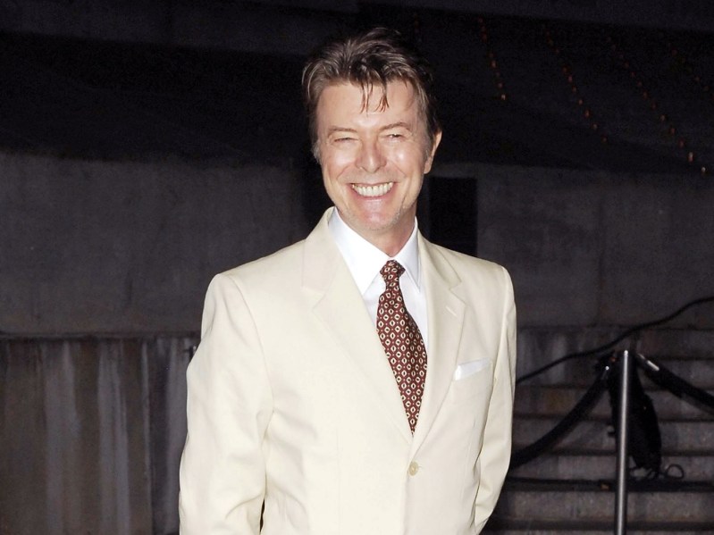 2007 photo of David Bowie smiling in a white suit