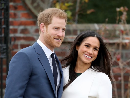 2017 photo of Prince Harry in a blue suit with Meghan Markle in a white outfit
