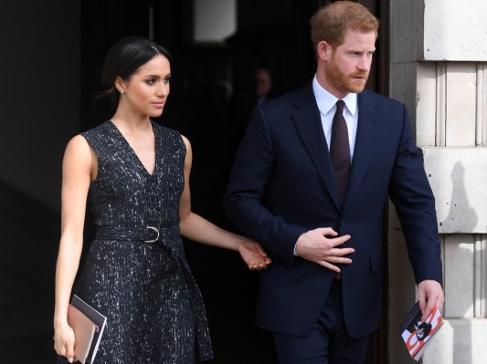 Meghan Markle (L) walking with Prince Harry in all black clothes