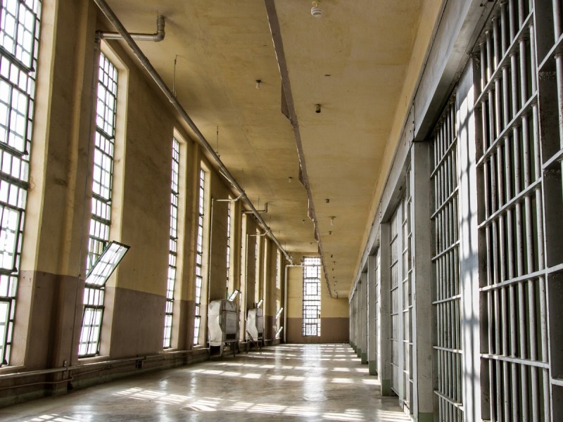 Photo of the inside of a prison hallway with light coming through windows