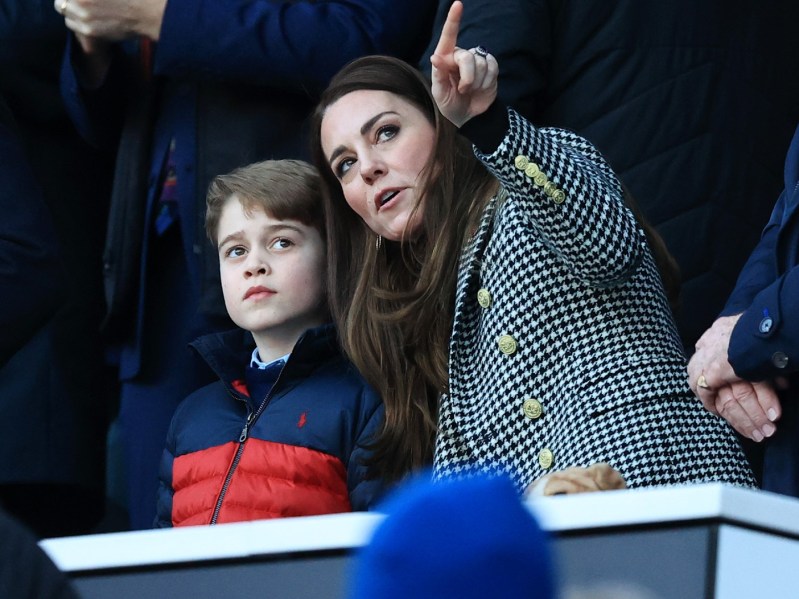 Kate Middleton with her arms around Prince George and pointing off into the distance