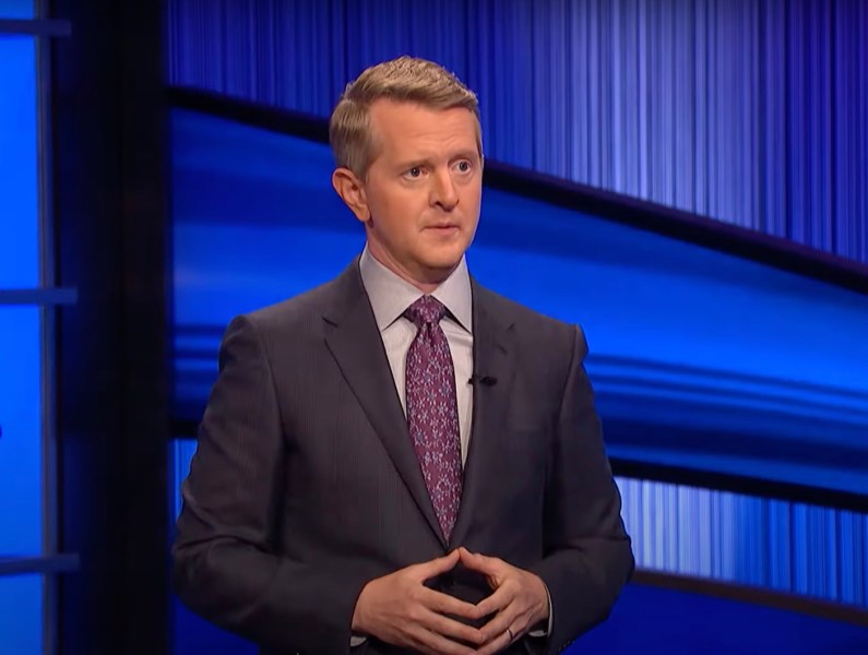 screenshot of Ken Jennings in a grey suit hosting Jeopardy!