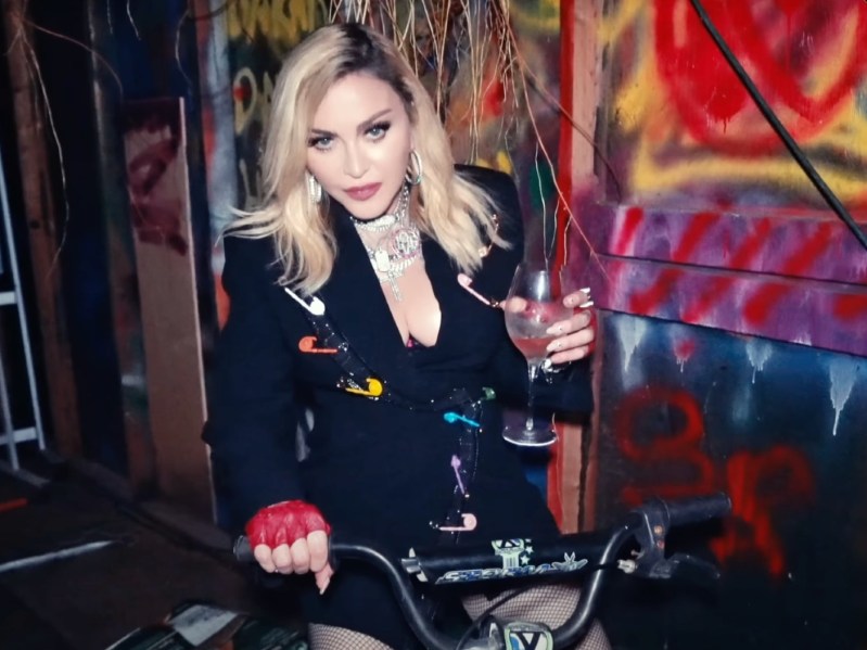 Madonna poses on motorcycle while holding wine glass