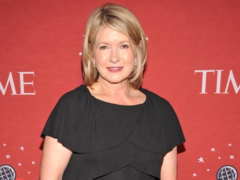 Martha Stewart wears black dress and poses against red backdrop