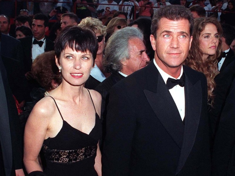 Mel Gibson (R) in black suit and bowtie standing next to Robyn Moore, who is wearing a black gown