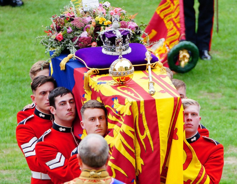 Queen Elizabeth's casket being carried by British soldiers in red uniforms
