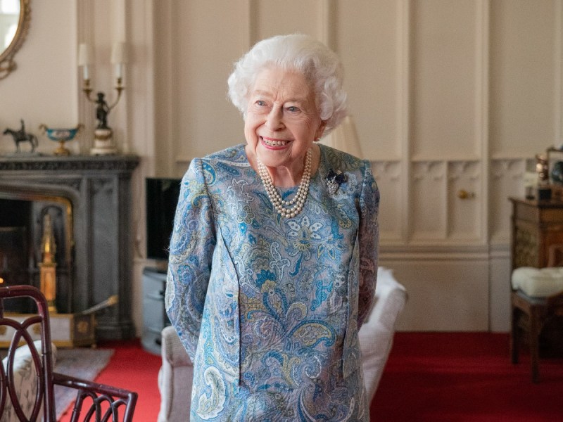 Queen Elizabeth smiles in blue dress