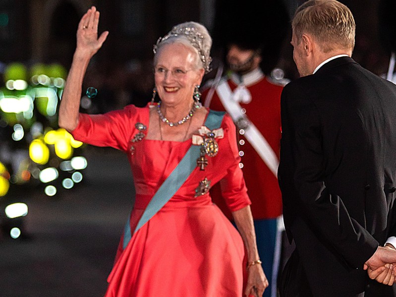 Queen Margrethe of Denmark waves in a red gown