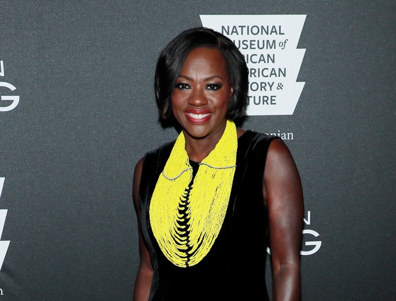 Viola Davis smiling in a black dress and yellow scarf
