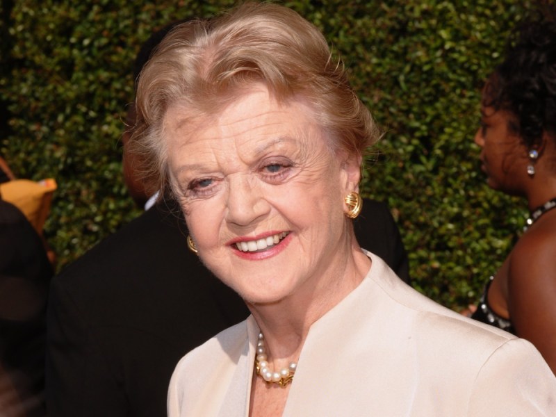 Angela Lansbury smiles in closeup image. She is wearing a cream-colored top