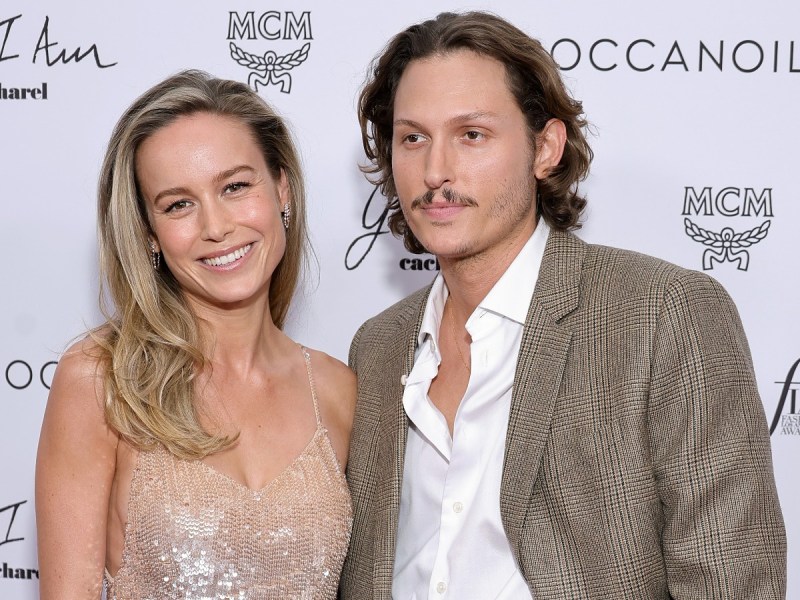 Brie Larson (L) smiles in sequined nude gown standing next to Elijah Allan-Blitz