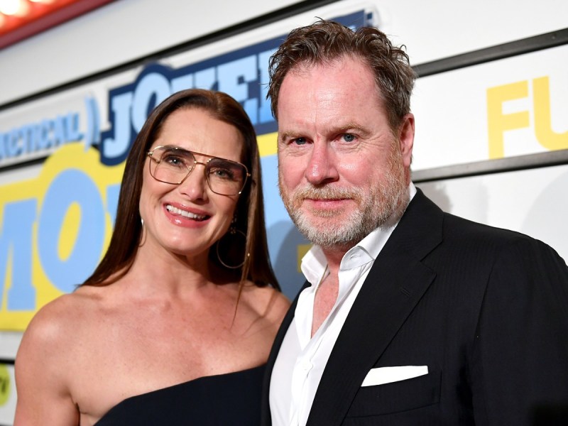 Brooke Shields (L) smiles in strapless dress next to husband Chris Henchy