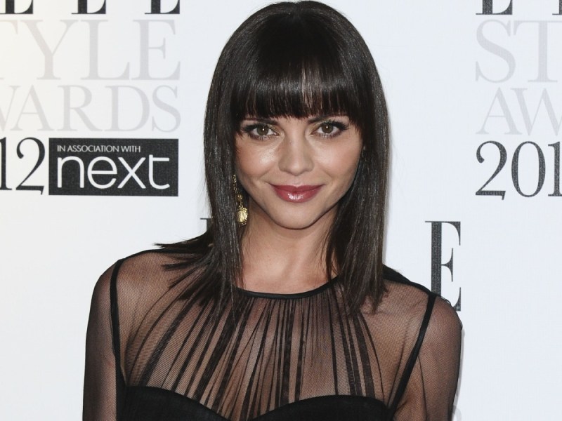 Christina Ricci smiles in sheer black dress and blunt bangs hairstyle