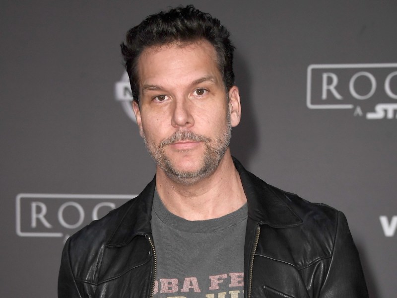 Dane Cook poses in gray shirt with black jacket