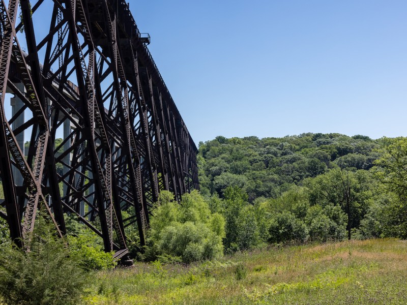 stock photo of a rusted railroad bridge in an Iowa forest