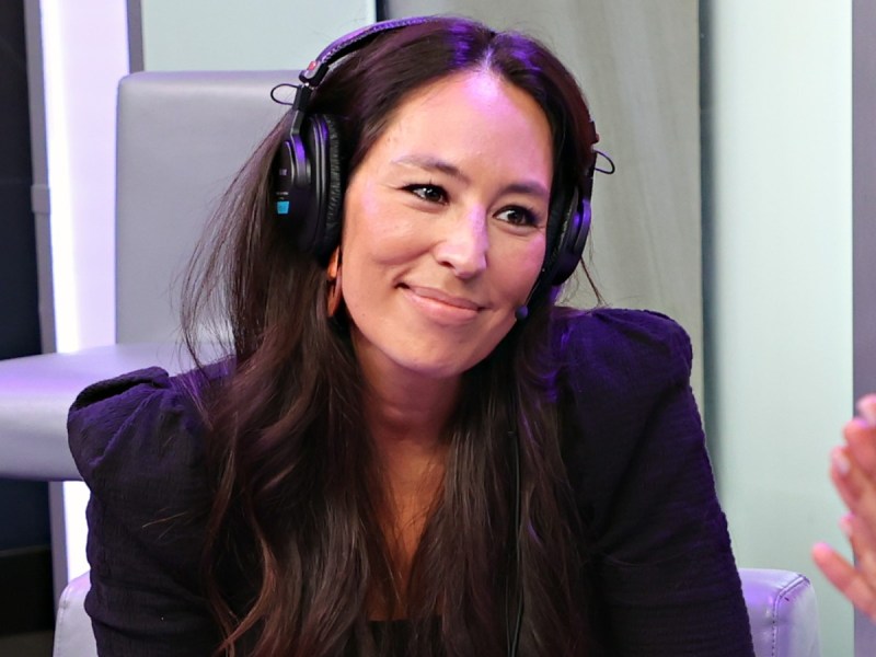 Joanna Gaines smiles in black top with headphones on
