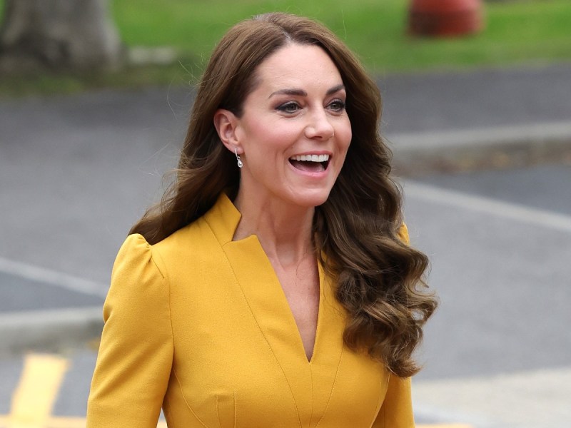 Kate Middleton smiles and laughs in bright yellow dress