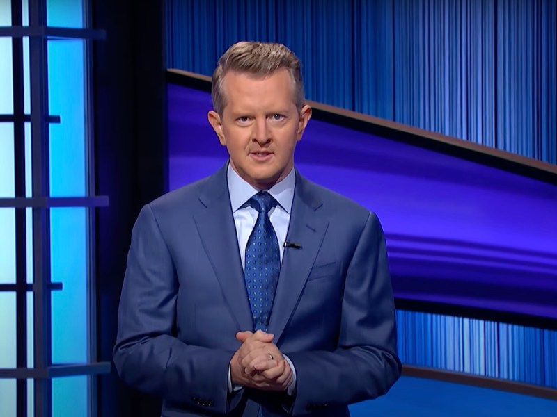 screenshot of Ken Jennings hosting Jeopardy in a blue suit and tie