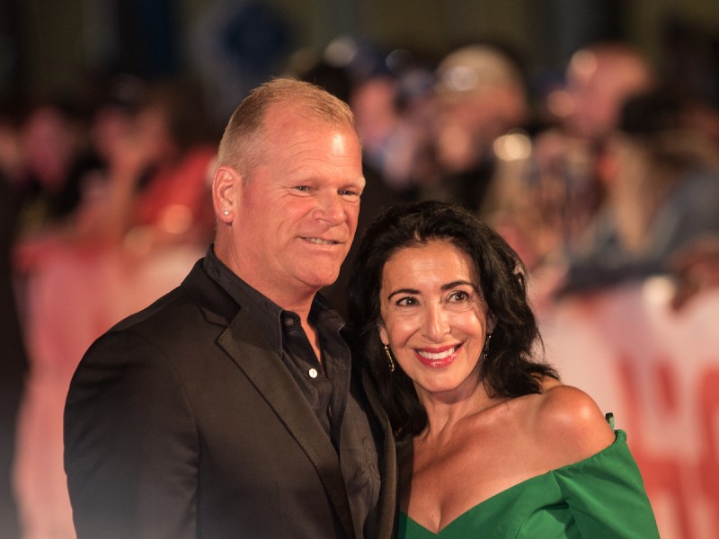 Mike Holmes in a black suit with wife Anna Zappia in a green dress in 2017