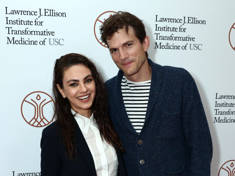 Mila Kunis in a black jacket with Ashton Kutcher in a blue cardigan