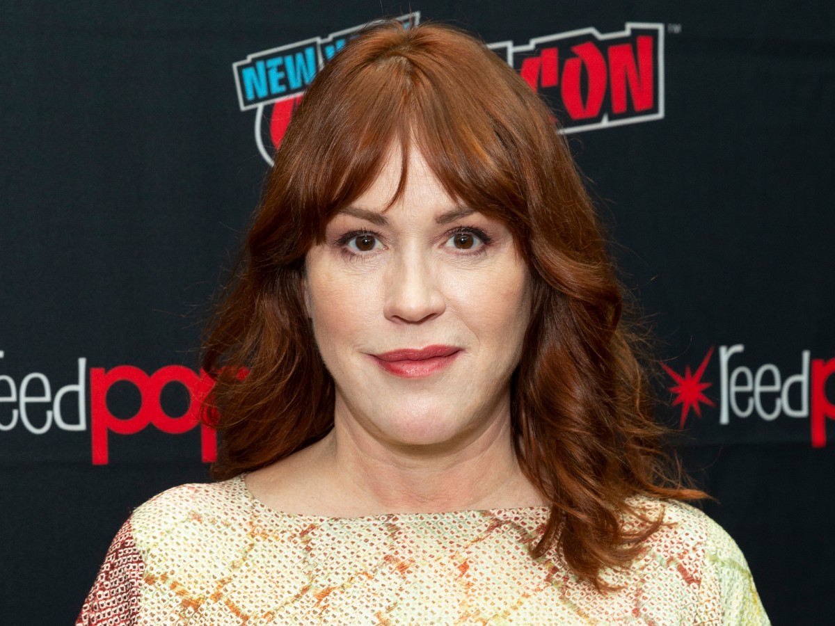 Closeup of Molly Ringwald smiling in yellow top