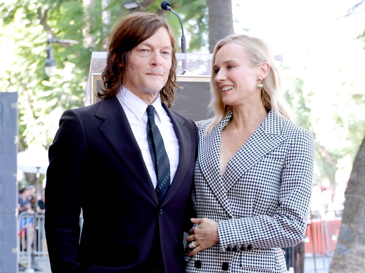Norman Reedus in a black suit with Diane Kruger in a white and black pantsuit