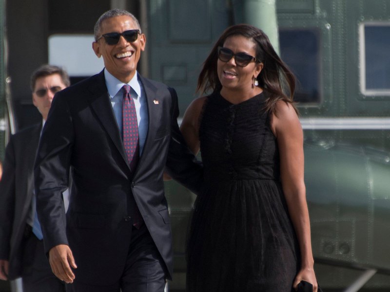 2016 photo of Barack Obama with his arm around Michelle with both laughing in front of Marine One