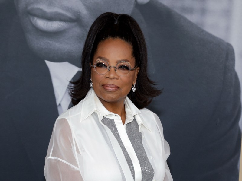 Oprah Winfrey smiling in a sheer white and silver dress