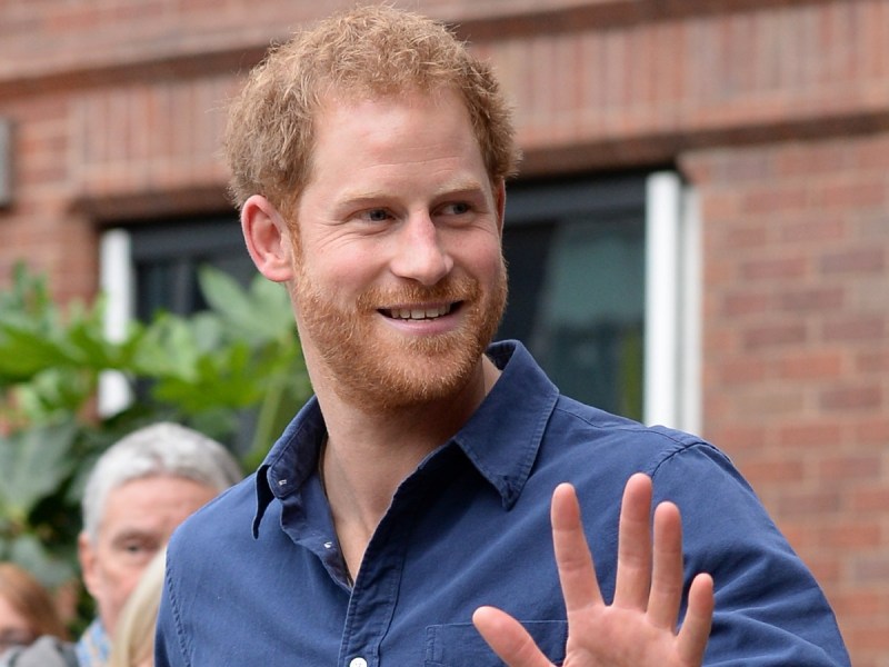 Prince Harry smiles and waves in blue button down