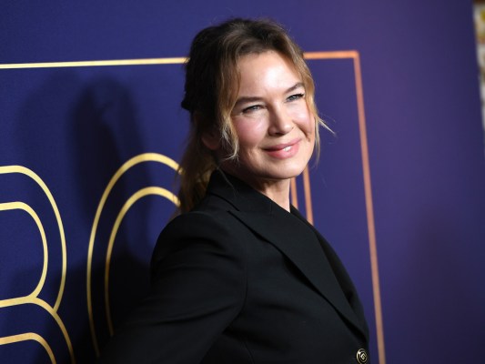 close up of Renee Zellweger smiling in a black jacket