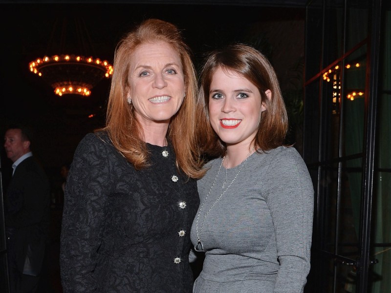 Sarah Ferguson (L) in black top standing next to Princess Eugenie, who is wearing a gray top
