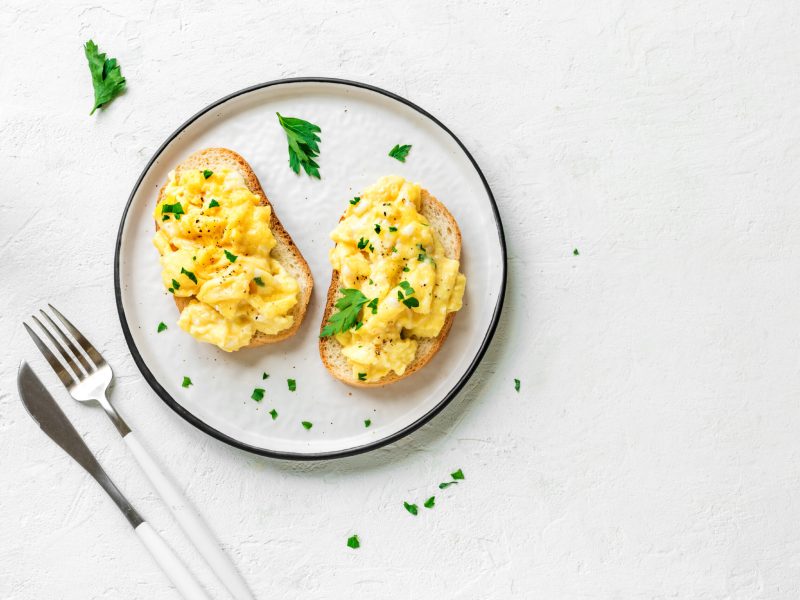 Scrambled eggs on toast with fresh herbs
