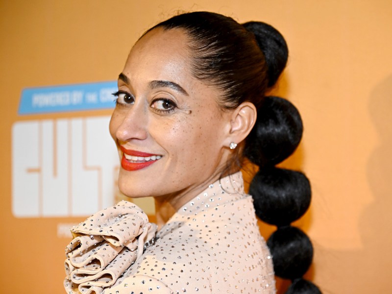 close up of Tracee Ellis Ross smiling in a dotted beige top with red lipstick