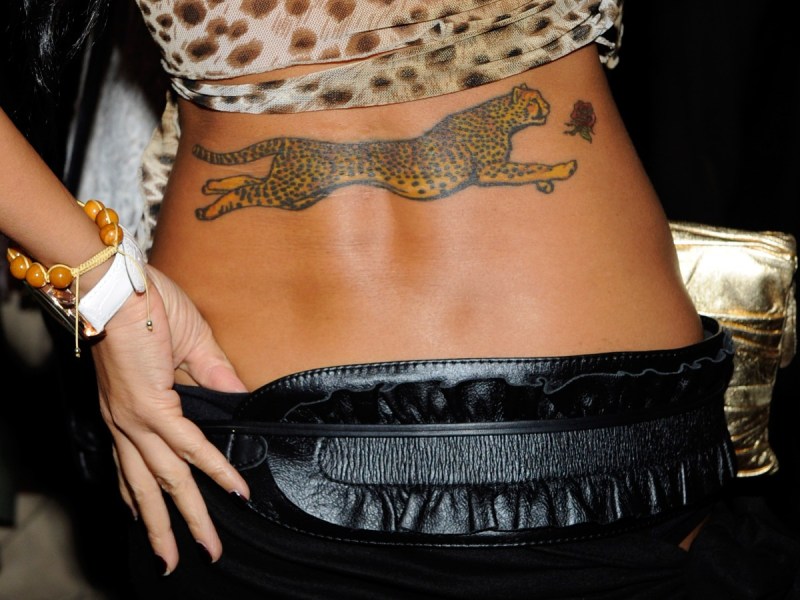 Closeup photo of a lower back tattoo depicting a cheetah running