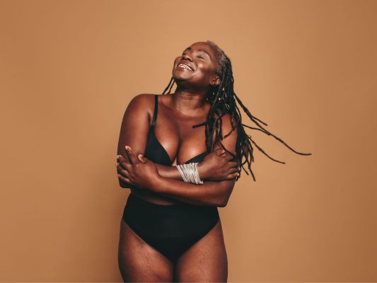 Black woman embracing her curvy figure and smiling
