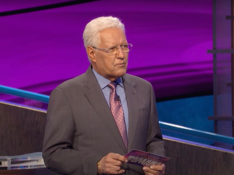 screenshot of Alex Trebek in a grey suit hosting Jeopardy