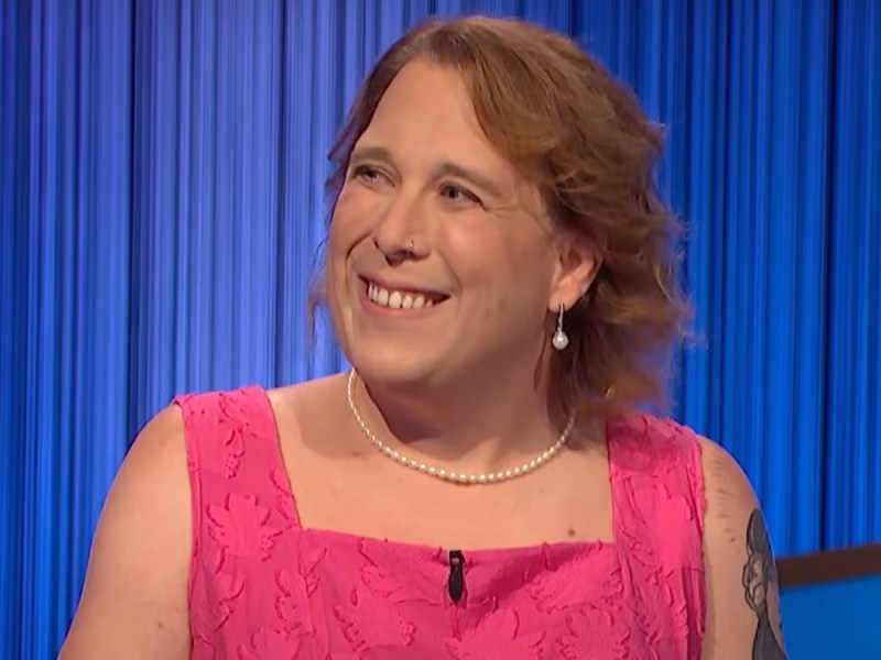 Amy Schneider smiles in hot pink dress on "Jeopardy!" stage